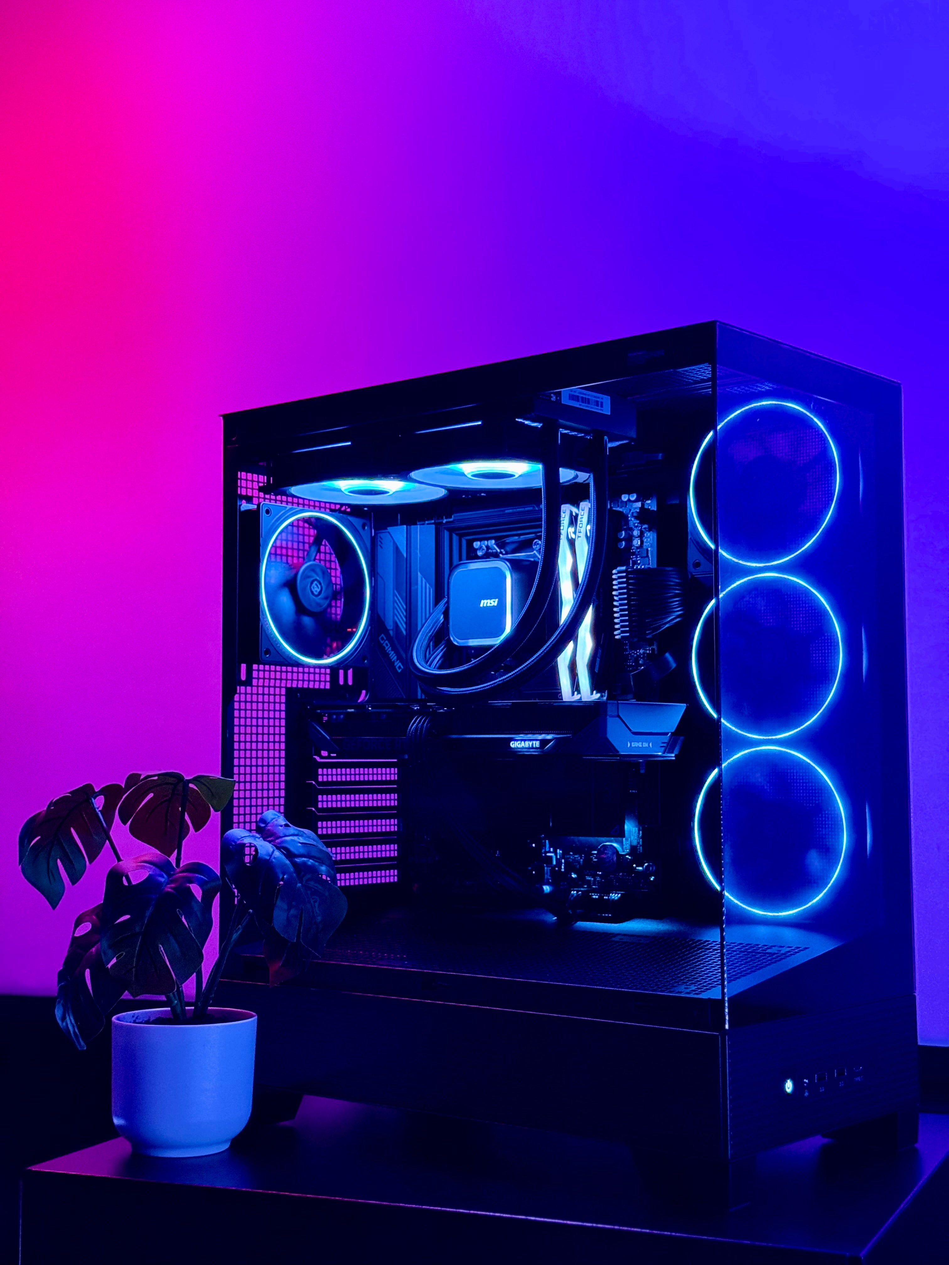 Glossy computer case with RGB lighting on a gradient purple and pink background