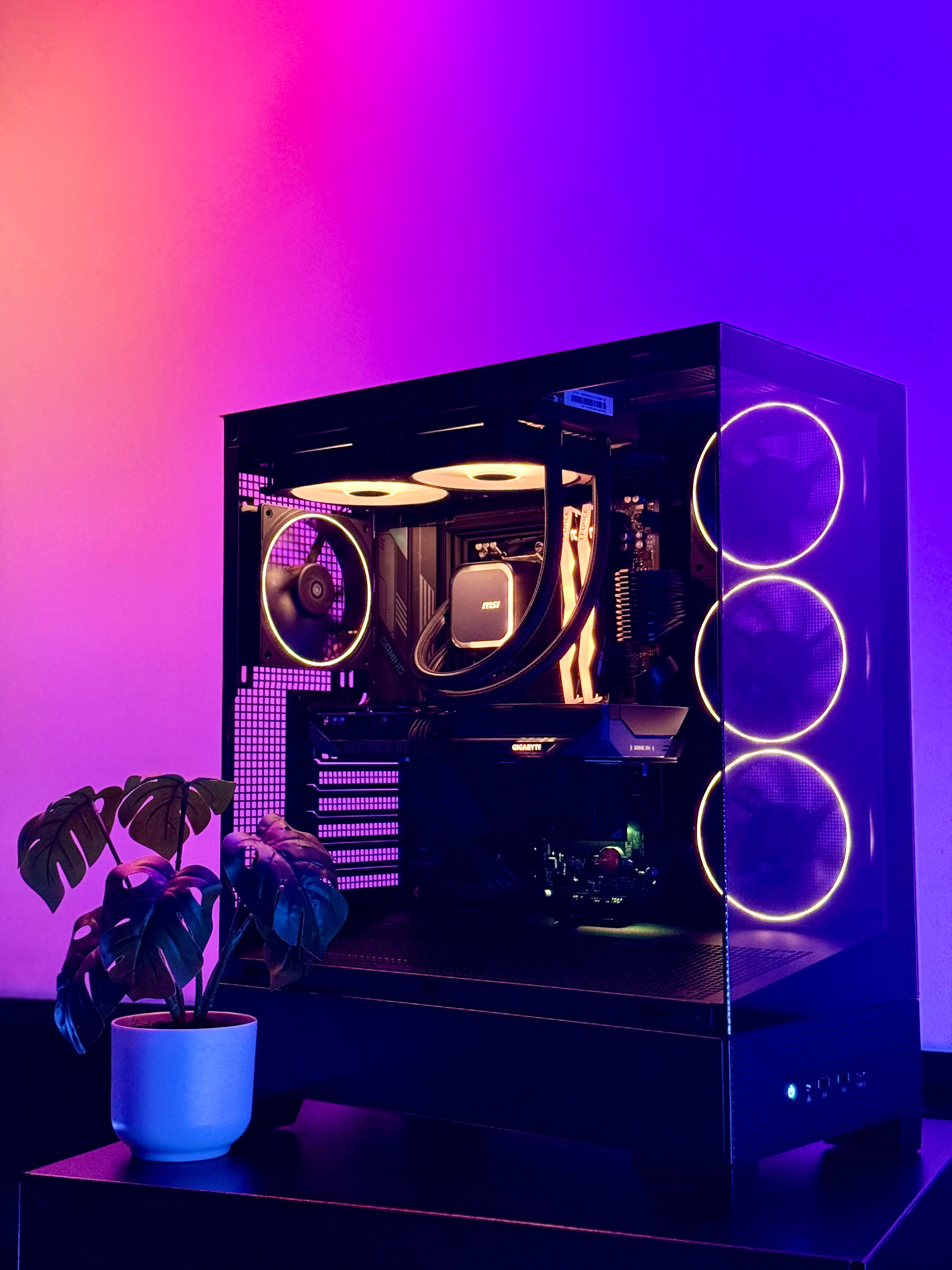 Glossy black computer case with RGB lighting on a purple gradient background