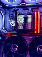 Close-up of a computer case with RGB lighting and a monitor displaying a character in a hat.