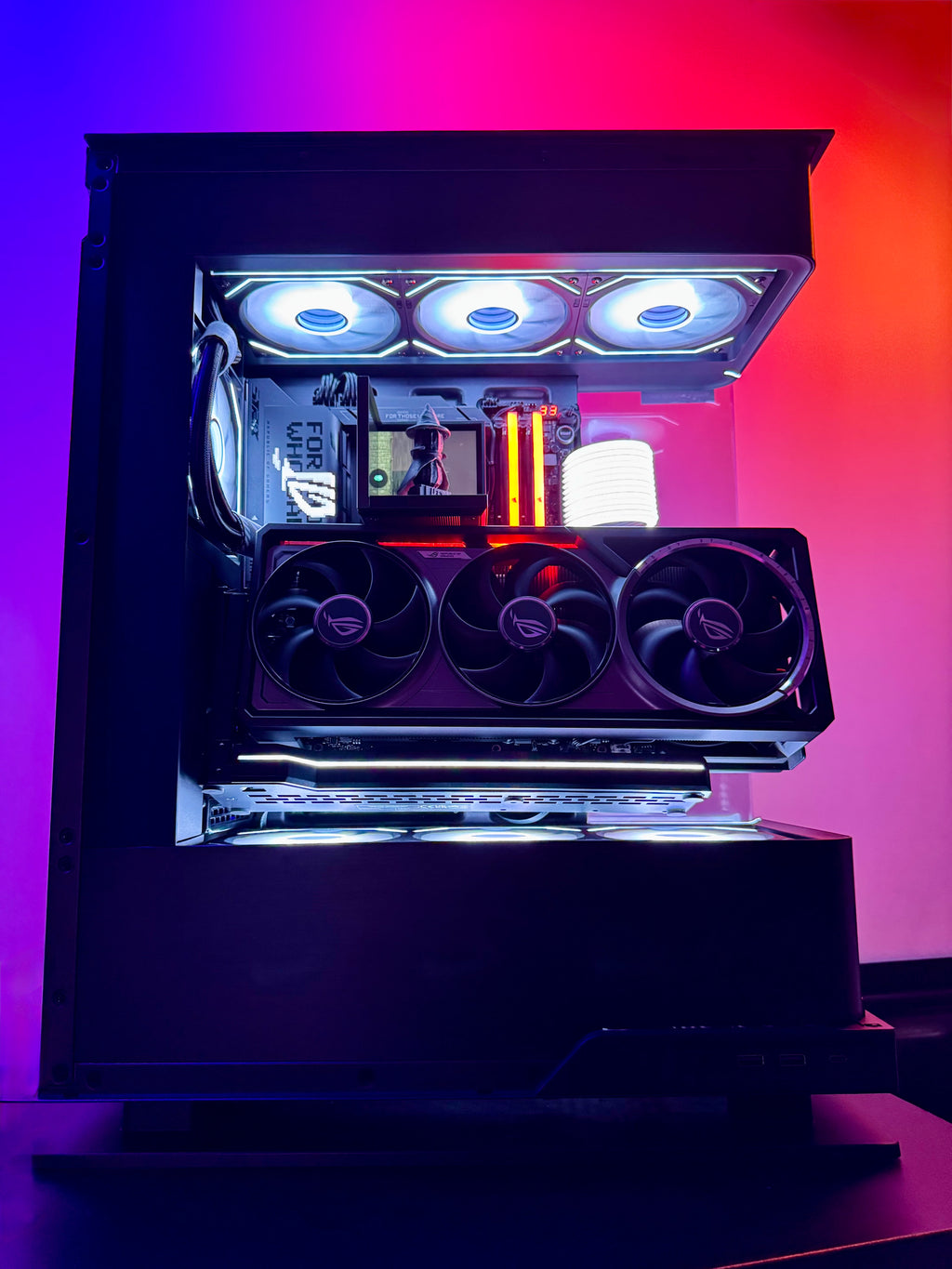Glossy gaming PC case with RGB lighting on a gradient purple and orange background