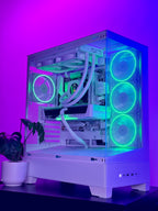 A white custom-built desktop PC tower with a clear side panel, showcasing a white liquid CPU cooler and internal components. The PC is illuminated by glowing green and blue LED fans and lighting, set against a purple and blue ambient background with a small potted plant on the left.
