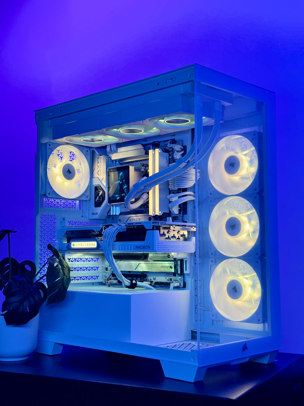 A custom-built desktop PC tower with a transparent side panel, showcasing internal components, liquid cooling tubes, and three illuminated white fans on the right side, set against a blue-lit background.