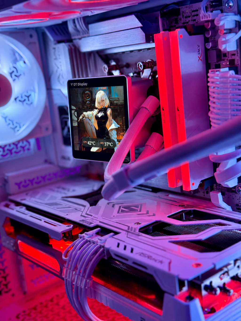 Close-up of a custom PC interior with white and light gray components illuminated by pink, purple, and red LED lighting. A small display screen is mounted on the front, showing a video, while cables and cooling tubes run through the chassis.