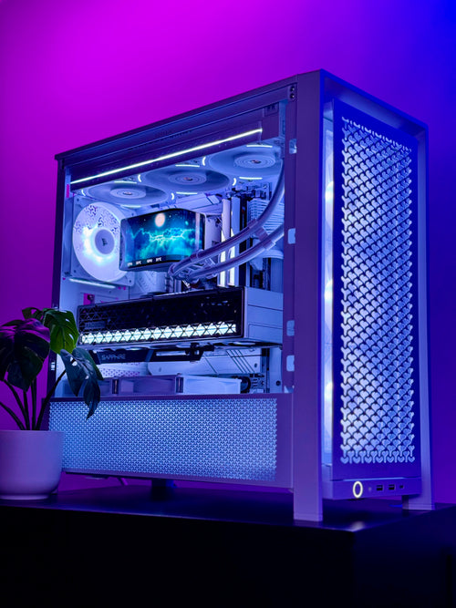 A custom-built desktop PC inside a white metal case with a glass side panel, showcasing a liquid CPU cooler, multiple cooling fans, and a graphics card. The setup is illuminated by cool blue and purple LED lighting, set against a matching purple-lit background with a small potted plant on the left.