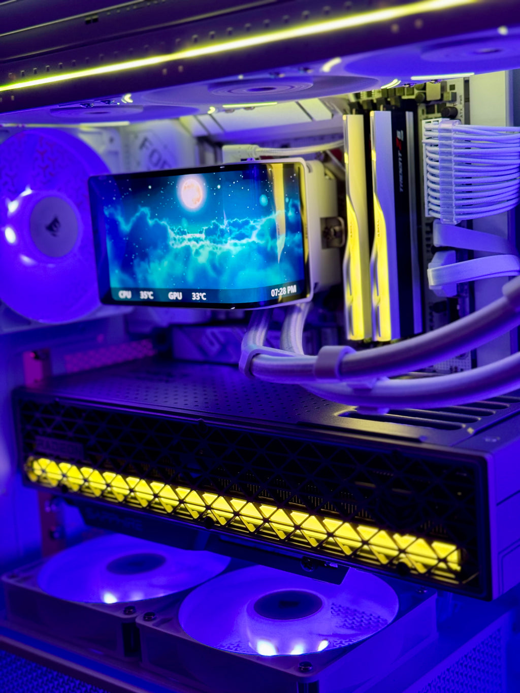 A close-up of a custom PC interior with RGB lighting, featuring a liquid CPU cooler, RAM sticks, a monitor, dual fans, and a long LED light bar glowing in yellow and purple.