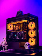 A custom black PC case with a glass side panel, illuminated by glowing orange and yellow RGB fans and internal lighting. The case is styled with Halloween decorations, including a skull, a small skeleton figurine, and a jack-o'-lantern on top, set against a vibrant purple and blue gradient background.
