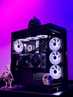 A custom-built desktop PC inside a black glass side-panel case, styled with skeleton and pumpkin Halloween decorations against a vibrant purple and pink gradient background.