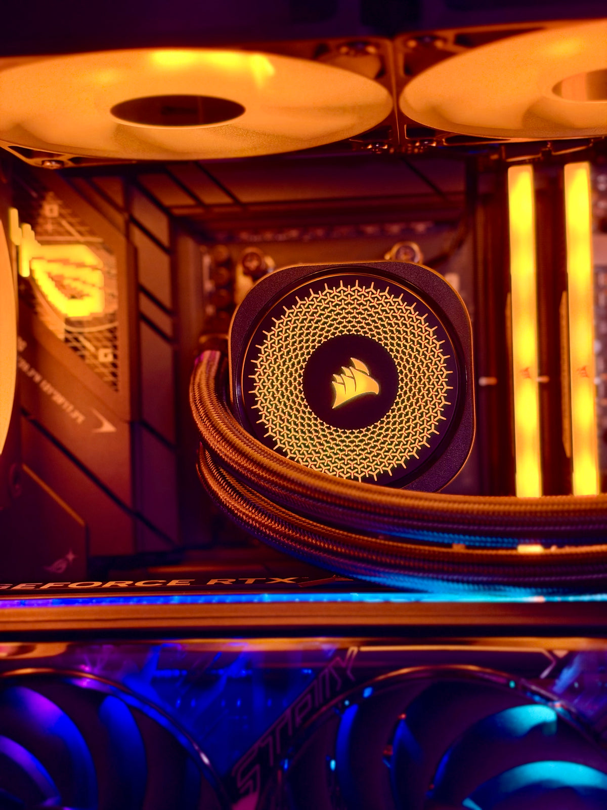 Corsair liquid CPU cooler with a glowing gold radiator and braided tubing inside a PC case, surrounded by RGB-lit fans.