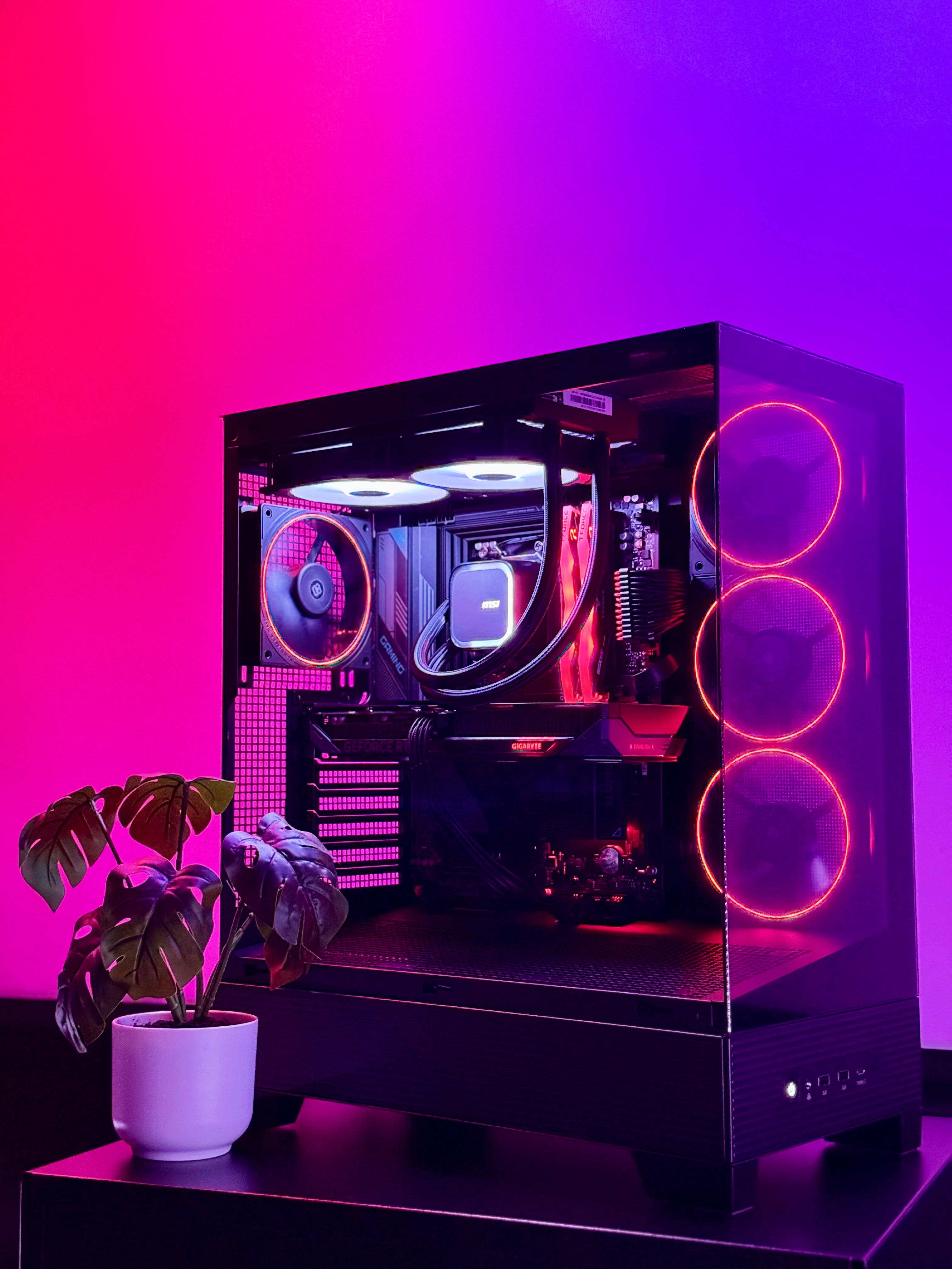 Computer case with RGB lighting on a pink and purple gradient background